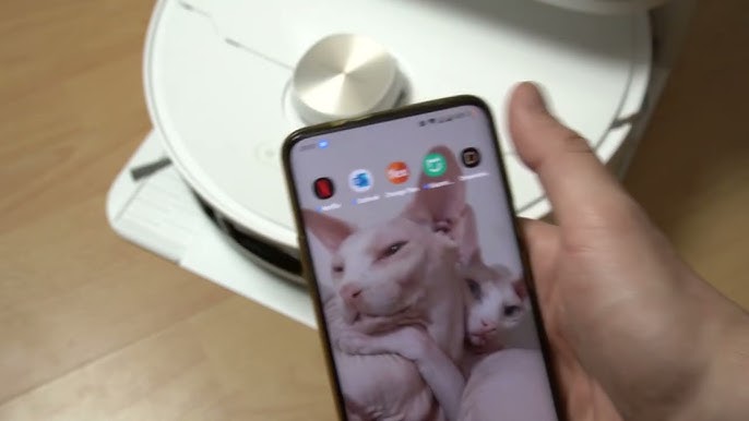 Personne consultant l'application sur smartphone pour contrôler son aspirateur robot connecté